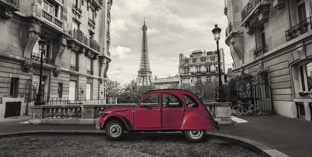 Eiffeltoren in Parijs en retro rode auto op de Avenue de Camoens