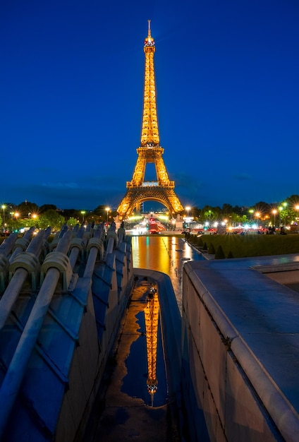 Eiffeltoren met avondverlichting en reflectie in het water