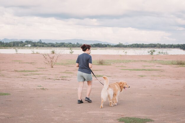 Eigenaar die samen met Golden retrieverhond loopt