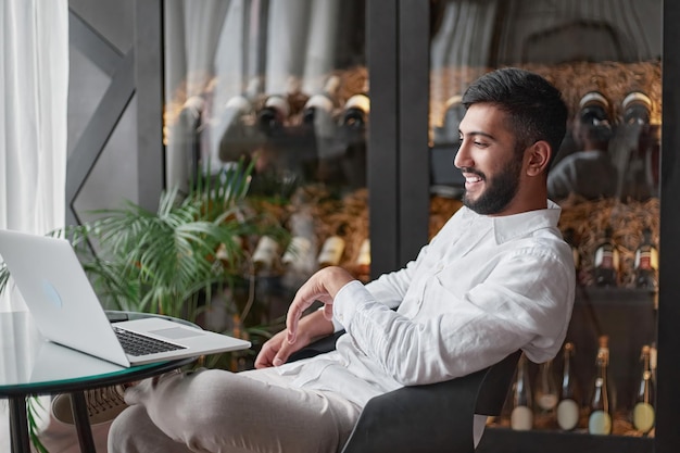 Eigenaar van een wijnbedrijf kijkt naar zijn laptopscherm in het proeflokaal