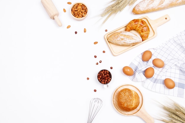 Eigengemaakte broden of broodje, croissant en bakkerijingrediënten op witte achtergrond.