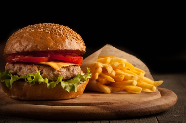 Foto eigengemaakte hamburger met rundvlees, ui, tomaat, sla en kaas. cheeseburger.