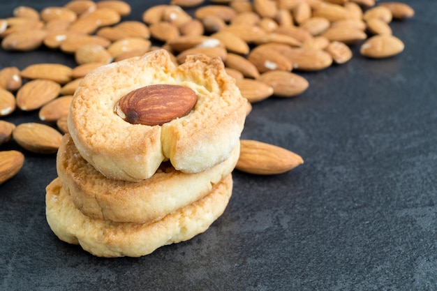 Eigengemaakte koekjes met amandelen op een donkere achtergrond.