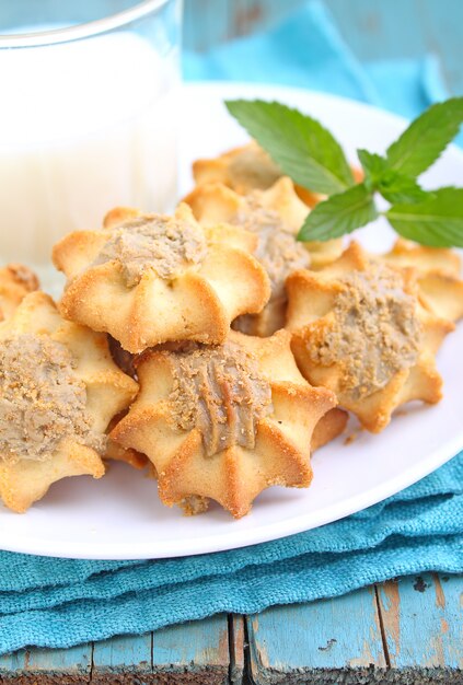 Eigengemaakte koekjes met halva op een witte plaat. Blauwe achtergrond