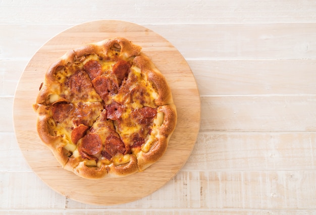 Eigengemaakte Pepperonispizza op houten plaat