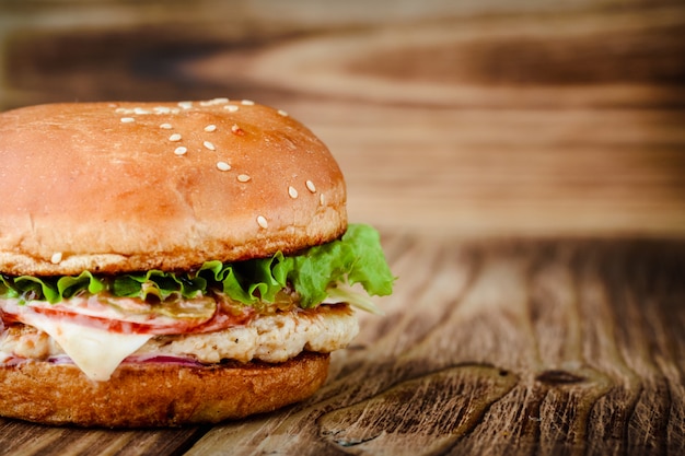 Eigengemaakte smakelijke chickenburger op een houten achtergrond