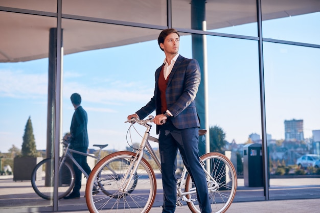 Eigentijdse zakenman met fiets op stadsstraat