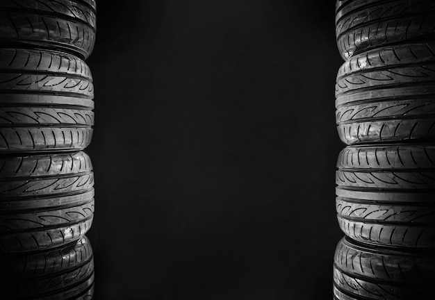 Фото Восемь автомобильных шин, изолированных на черном фоне свободного пространства в середине для текста.