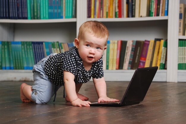 Eight months old toddler baby playing with tablet pc on the floor