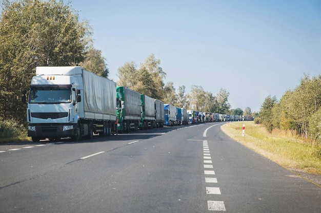 Eindeloze colonne vrachtwagens op de herfstweg