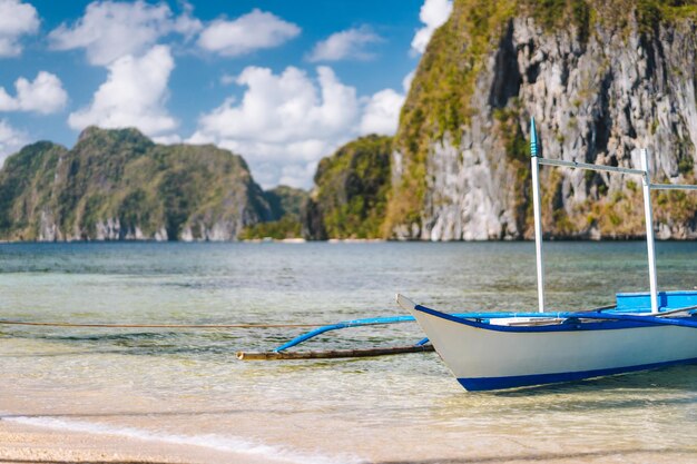 El Nido Close-up van traditionele Filippijnse boot aan wal met Pinagbuyutan-eiland op de achtergrond Palawan Bacuit-archipel Filipijnen