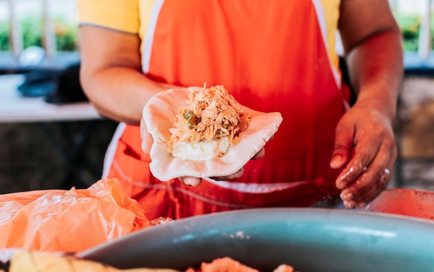 Elaboration of traditional pupusas elaboration of the dough for traditional pupusas Hands of saleswoman showing raw pupusa