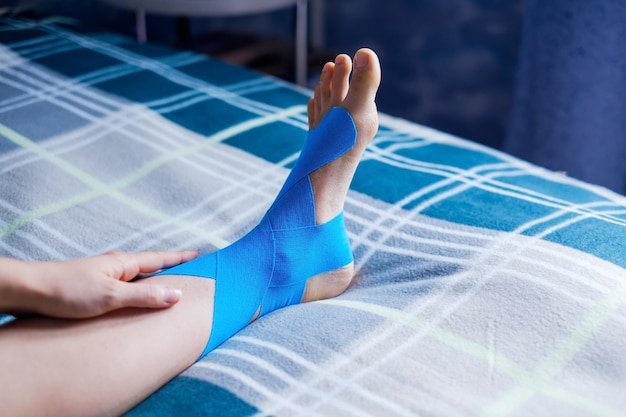 elastic therapeutic blue tape applied to patient's left leg