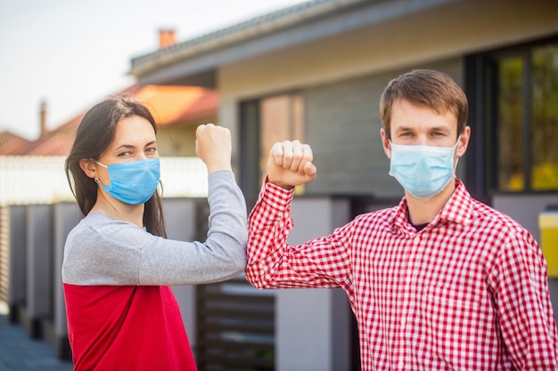 Elbow bump. Coronavirus, illness, quarantine, medical mask, COVID19. Couple greeting with elbows. E