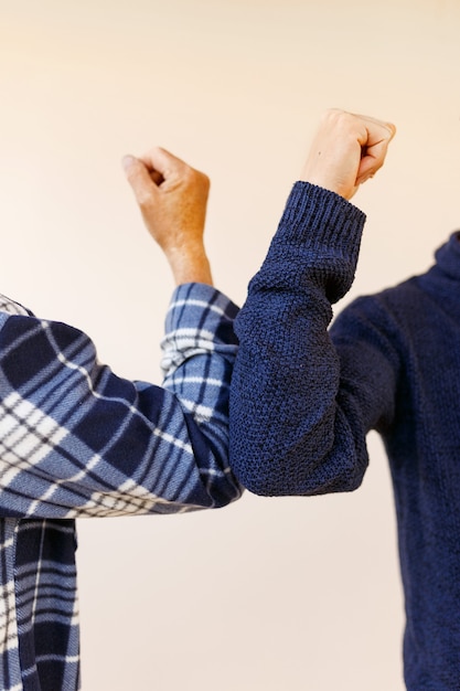 Foto saluto del gomito per evitare la diffusione del coronavirus. due amici salutano sbattendo i gomiti invece di salutare con un abbraccio o una stretta di mano. non stringerti la mano.