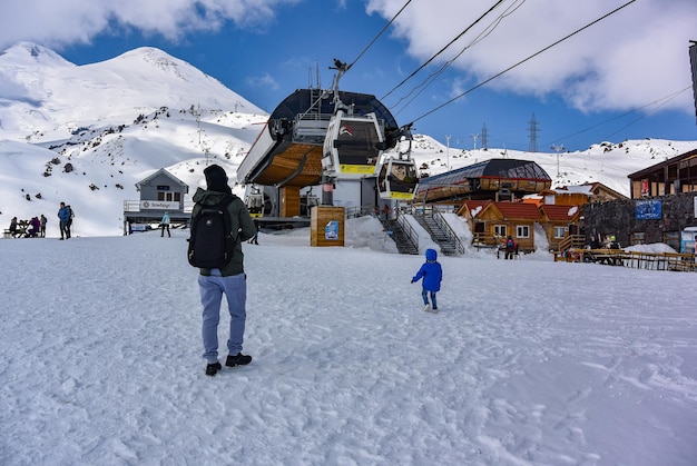 Elbrus Foto van een jonge man met een kind bij het Mir-station van de hoogste kabelbaan van Europa