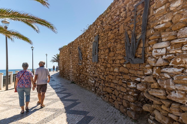 Elder couple walking in Luz beach near Lagos