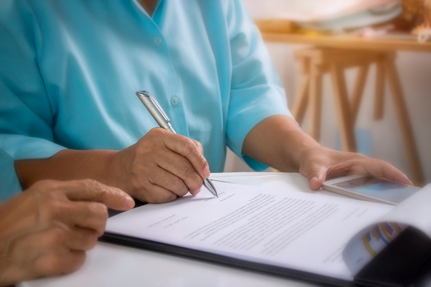 Foto l'anziano sta firmando un contratto di assicurazione sanitaria.