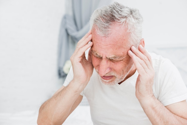 Photo elder man with a headache