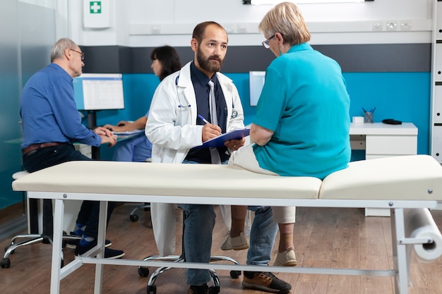 Elder patient discussing with doctor about osteopathy