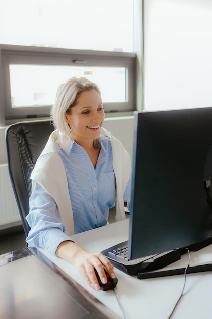 Elder woman working at a computer in the office