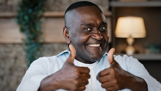 Elderly african american excited senior man happy winner grandpa showing two thumbs up positive hand