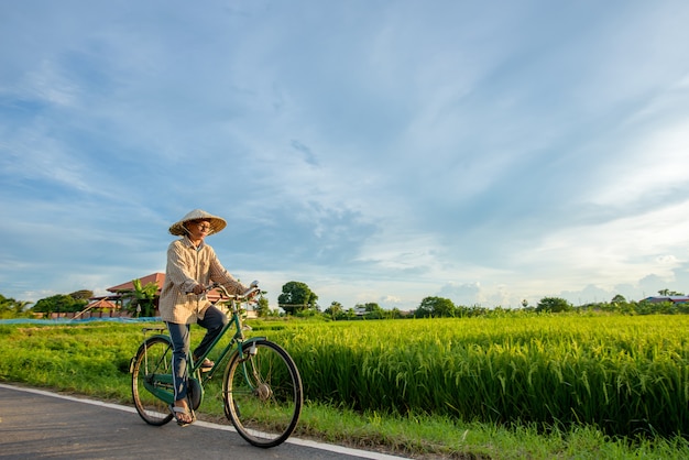 Elderly Asian farmer riding bike