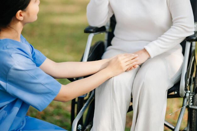 Elderly asian senior woman on wheelchair with Asian careful caregiver Nursing home hospital garden concept