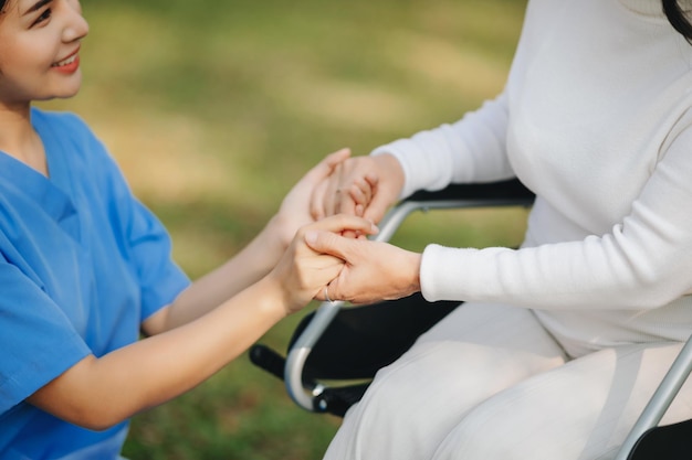 Elderly asian senior woman on wheelchair with Asian careful caregiver Nursing home hospital garden concept