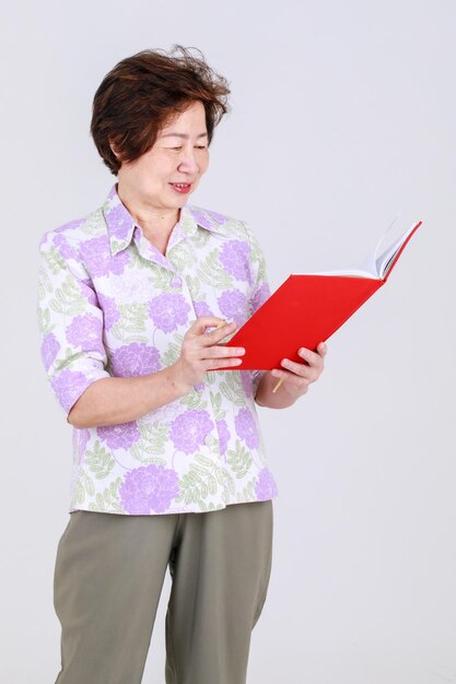 Elderly aunt, Senior Asian woman elderly teacher recording creative idea by writing a memo on note board on white background concept