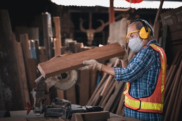 Photo an elderly carpenter works the wood with meticulous care