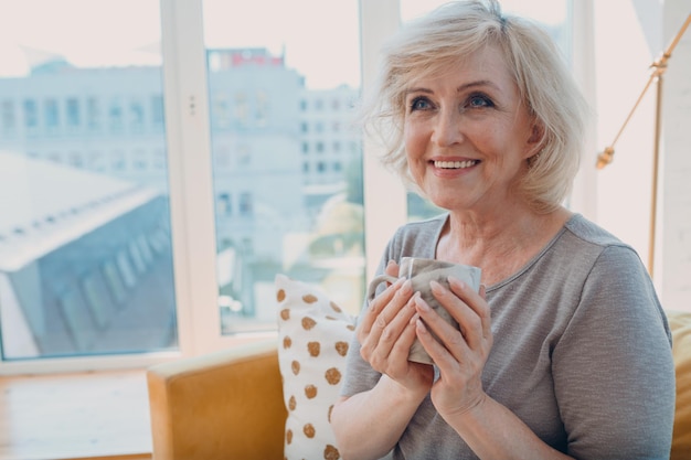 Elderly caucasian old aged woman enjoying afternoon tea at home