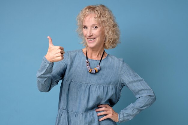 Elderly caucasian woman holding her thumb up