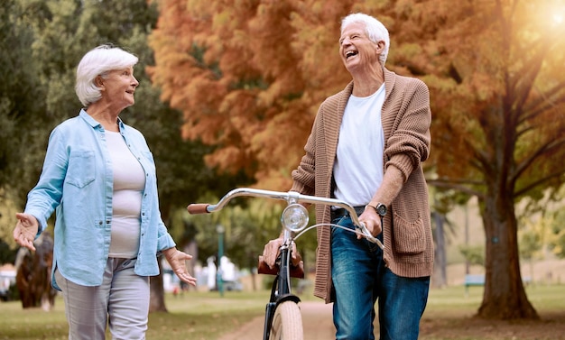 写真 自然の散歩と運動のための公園での老夫婦と自転車屋外の年配の男性は、老婆との面白い冗談を笑い、環境にやさしい旅行ニューヨークでのウォーキングサイクリング自転車と退職