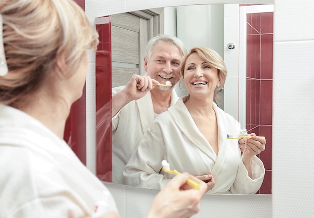 Foto coppia di anziani lavarsi i denti in bagno