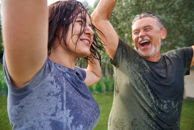 Photo elderly couple dancing in rain