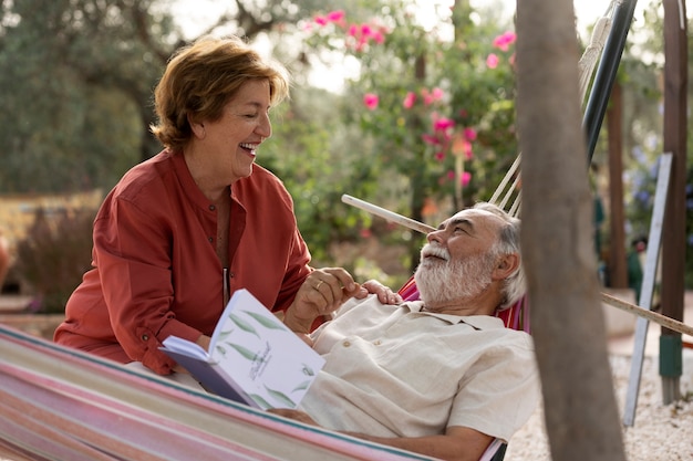 Elderly couple enjoying life in the countryside home hammock