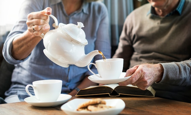 Photo elderly couple enjoying tea togetheraving