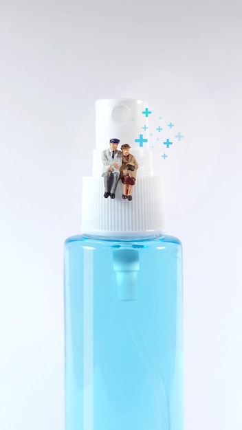 Elderly couple figure sitting on a alcohol spray bottle Covid19 concept