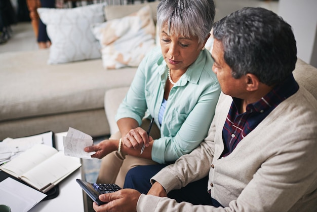 Photo elderly couple finance budget and life insurance discussion with banking details and bills retirement fund senior people and communication in a home living room with paperwork and contract