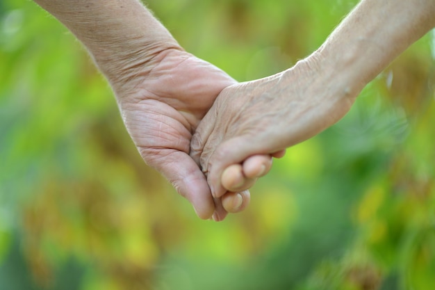 Elderly couple holding hands in autumn park