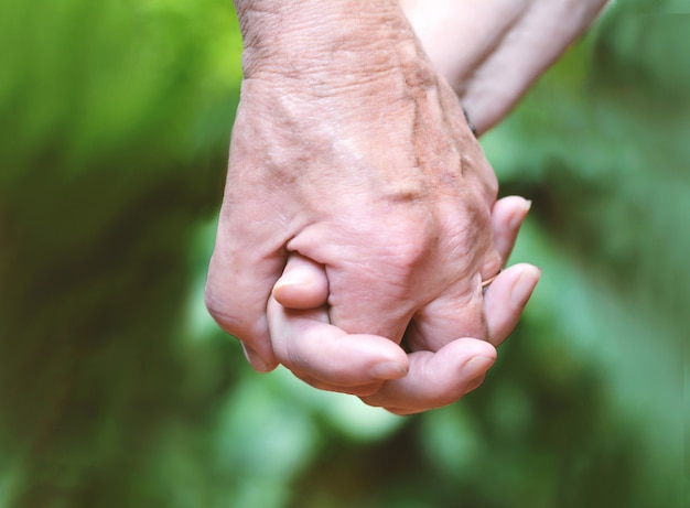 Elderly couple holding hands.