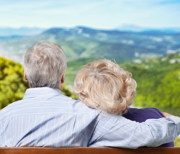 Elderly couple hugging on mountains view