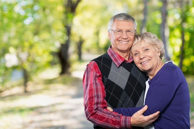 Elderly couple hugging and smiling at camera