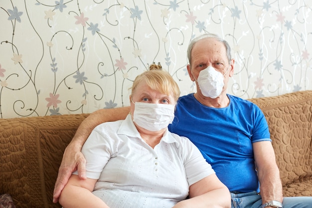 Elderly couple in medical masks, self-isolation mode for the elderly during the epidemic