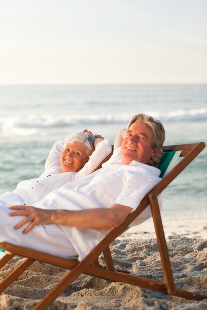 Elderly couple relaxing in their deck chairs