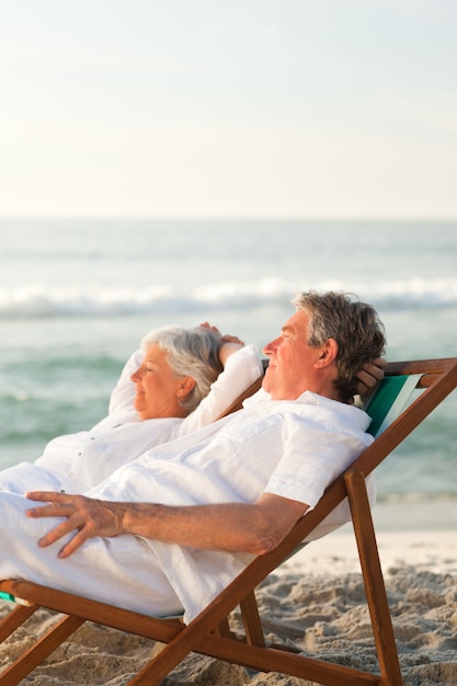 Elderly couple relaxing in their deck chairs