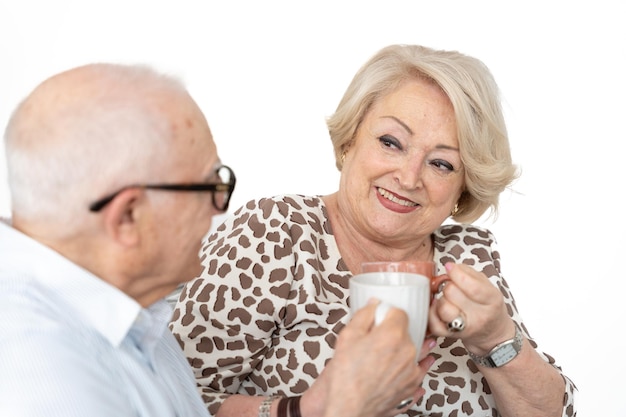 Elderly couple sharing cup of coffee together