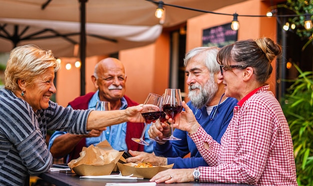 Foto coppie di anziani mangiano e bevono insieme vecchi amici si riuniscono in un ristorante