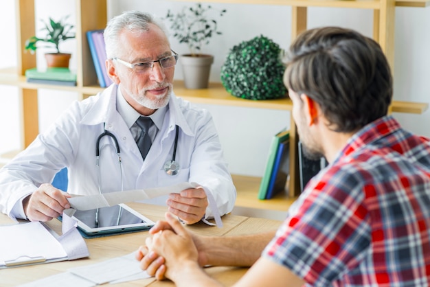 Elderly doctor listening to young patient